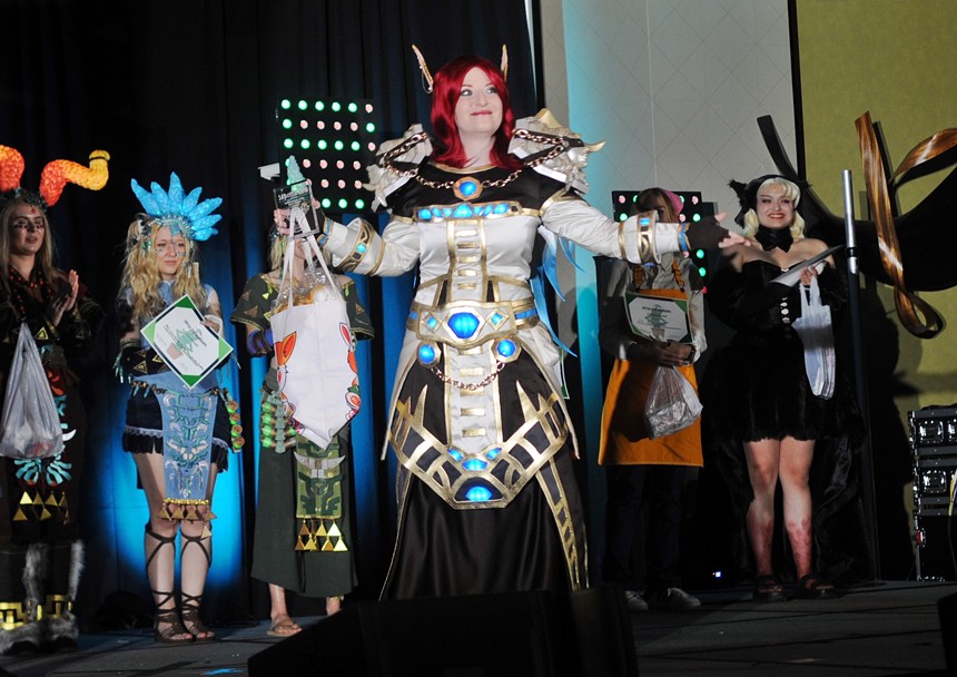 A female cosplayer stands on a stage.