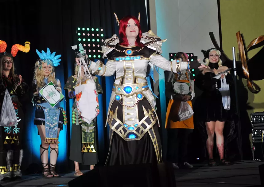 A female cosplayer stands on a stage.