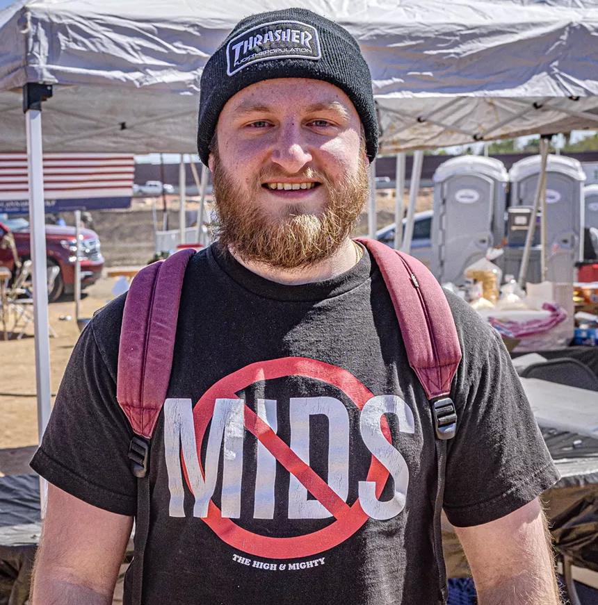 a man in a beanie and a t-short that says "no mids"