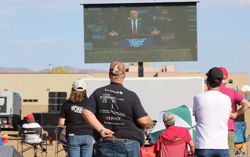 Supporters of Donald Trump watch a video feed of his rally outside the Findlay Totoya Center in Prescott Valley. Seen from behind, one man has his hand down the back of his pants.