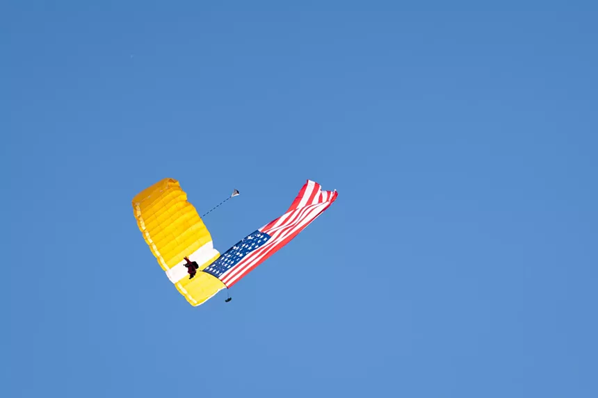 a skydiver with an american flag seen from below
