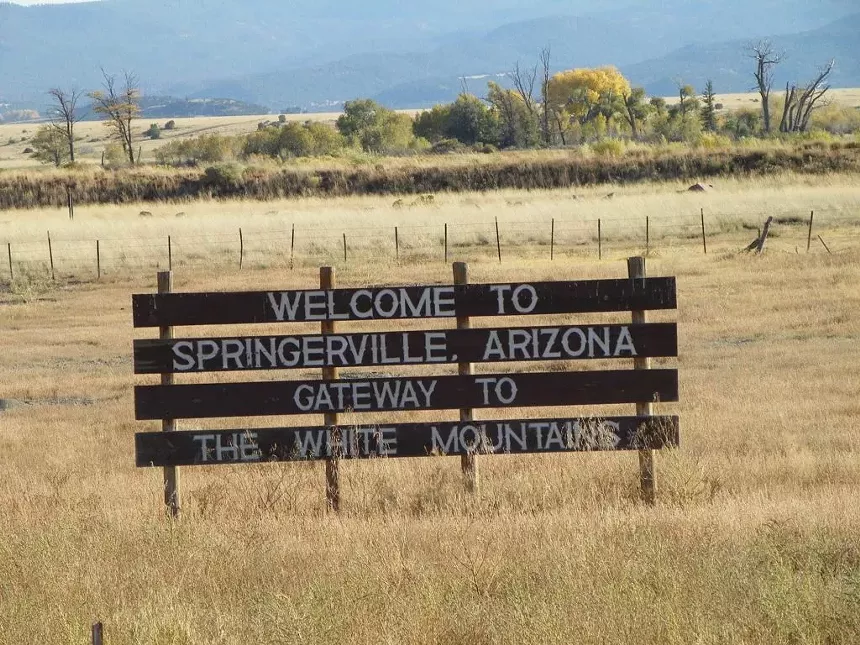 a sign in a brown field that says "welcome to springerville, Arizona, gateway to the white mountains"