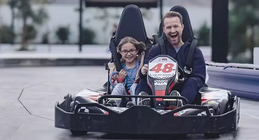 A father and daughter riding go-karts.