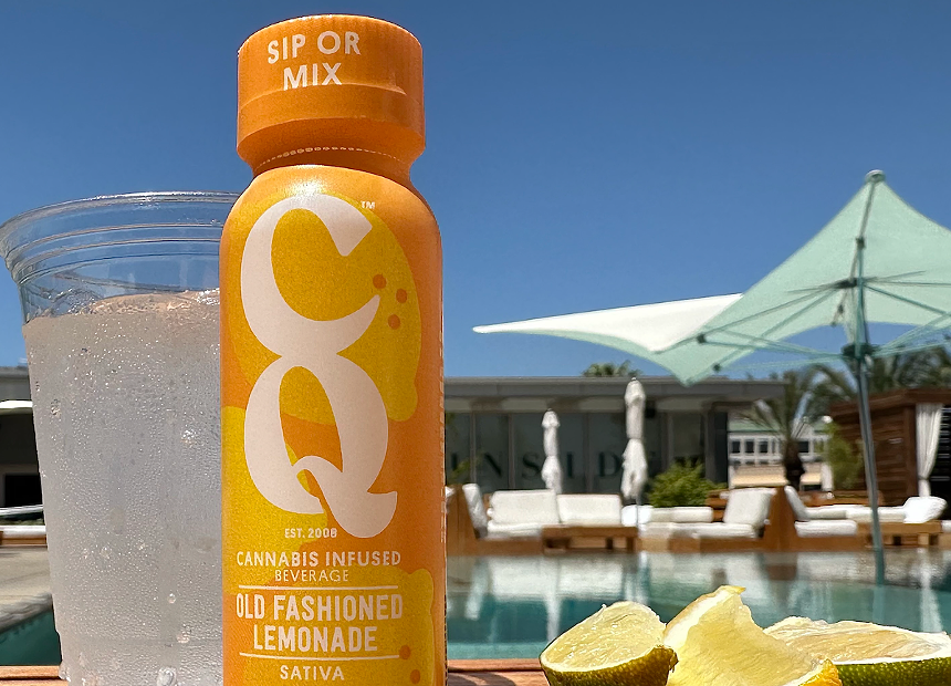 a bottle of CQ's "old fashioned lemonade" next to a pool on a summer day