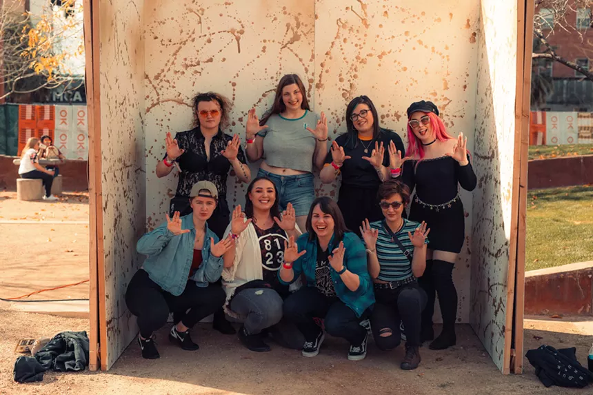Group of peoiple pose in front of backdrop