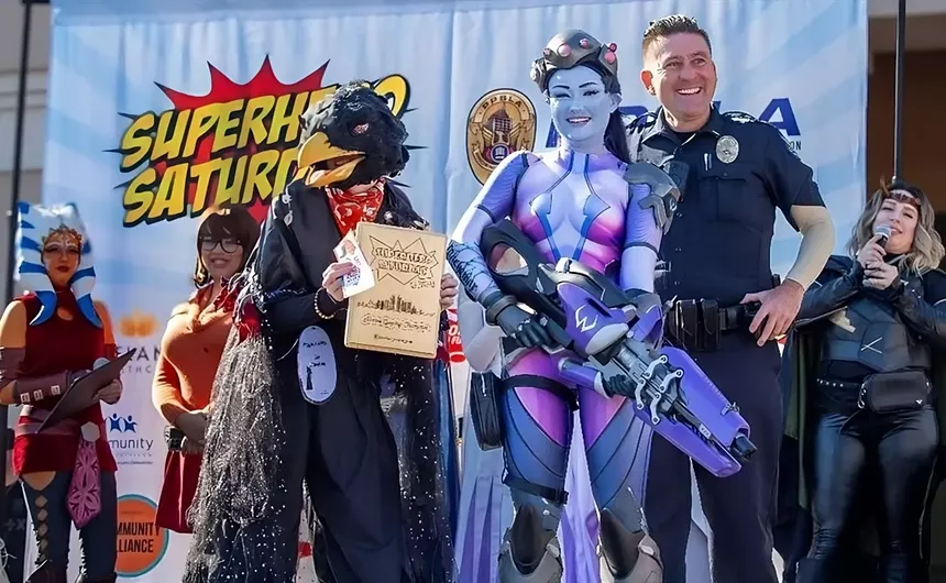 Cosplayers onstage, along with a police officer.
