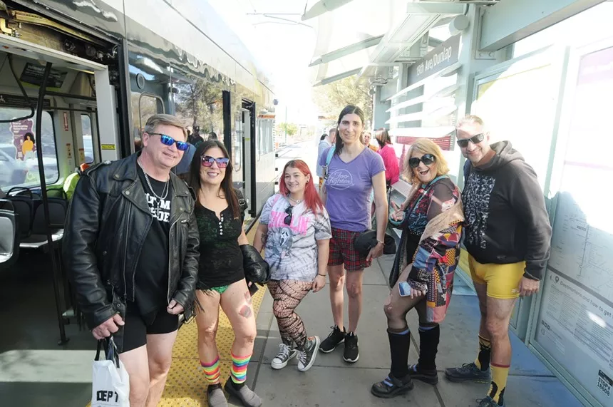People standing at a rail station.
