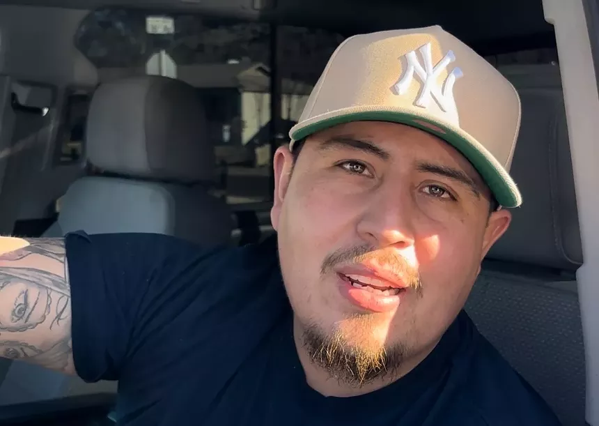a man in a tan new york yankees hat