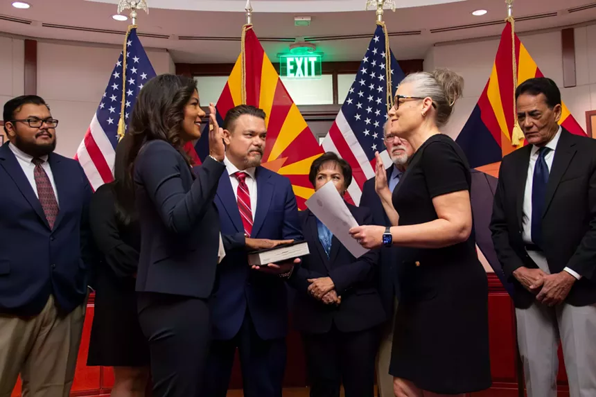 the swearing in of a judge with the Arizona state flag in the background