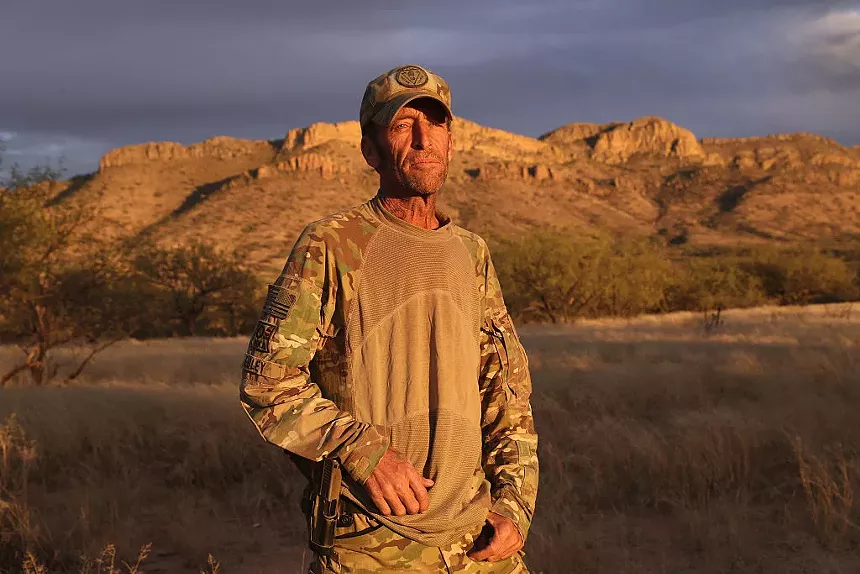 a man in camo stands outside in rural arizona