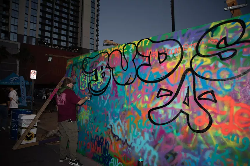 someone tags a spraypainted wall