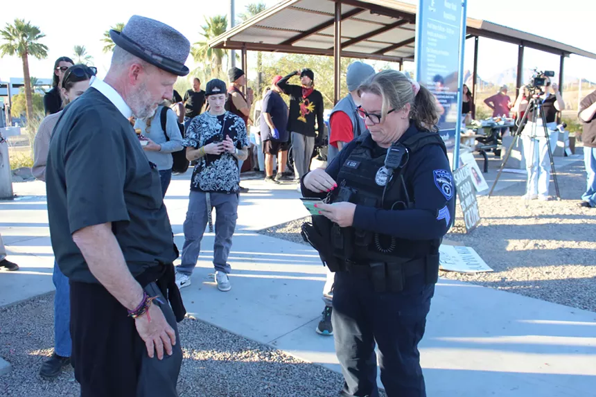 a police officer writes on a pad in front of an older man