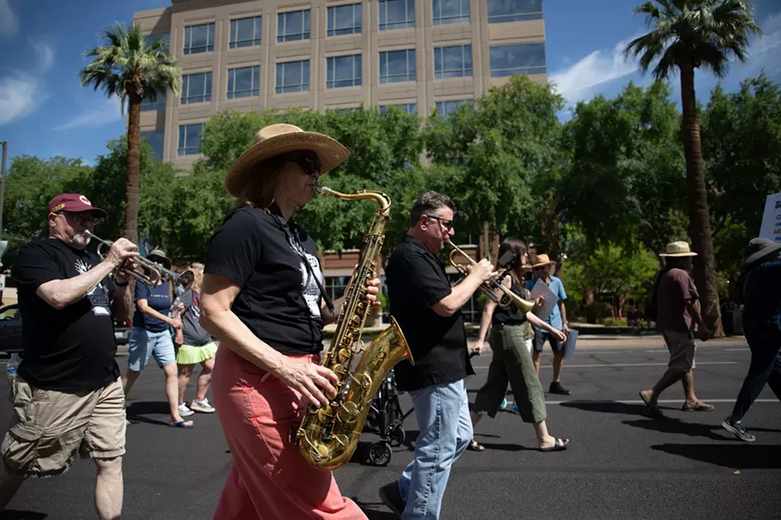 protesters play horns on a march