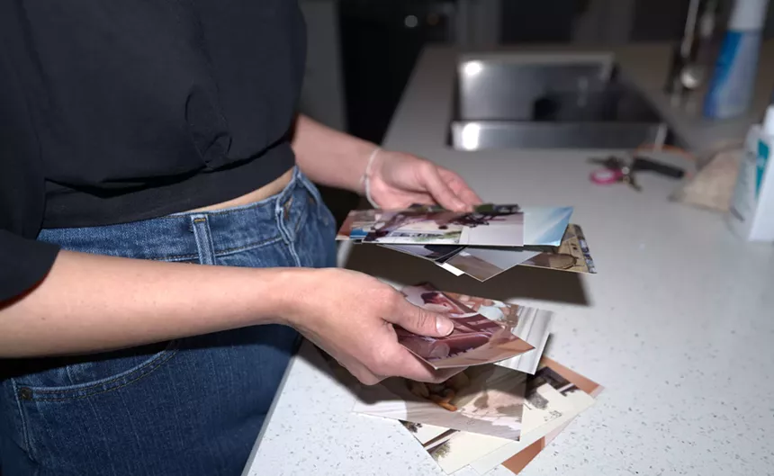 hands hold a pile of printed photographs
