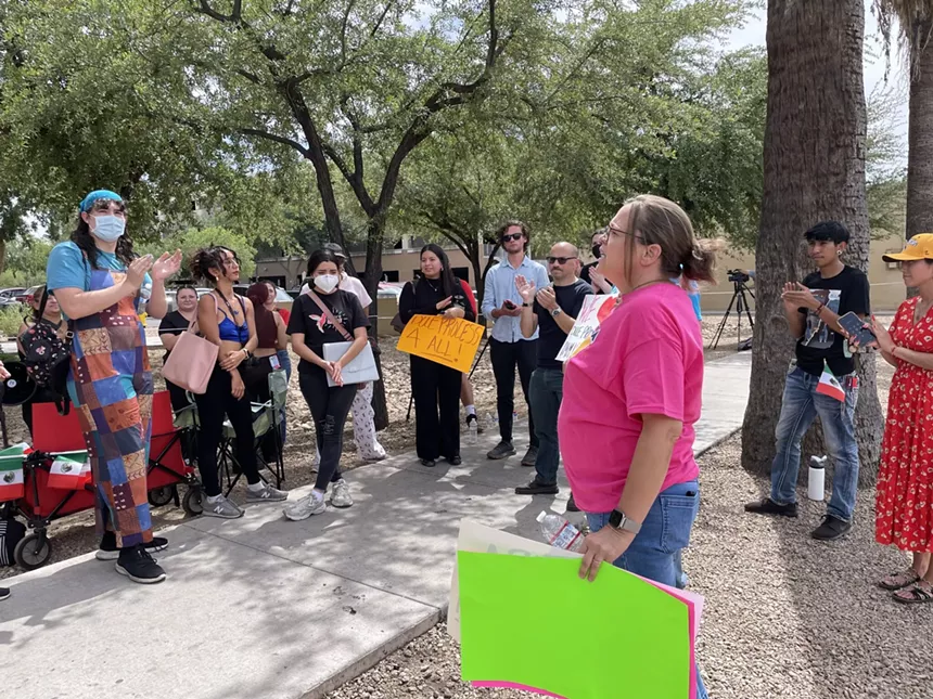 a woman speaks to a crowd of protesters