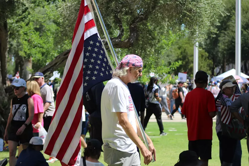 a man holds an upside-down american flag