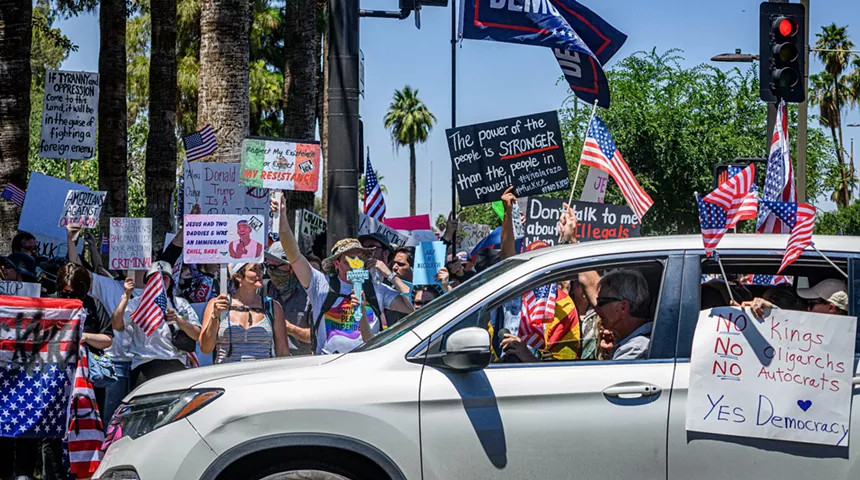 a protester holds a sign that says "our soldiers did not die for this sh*t"
