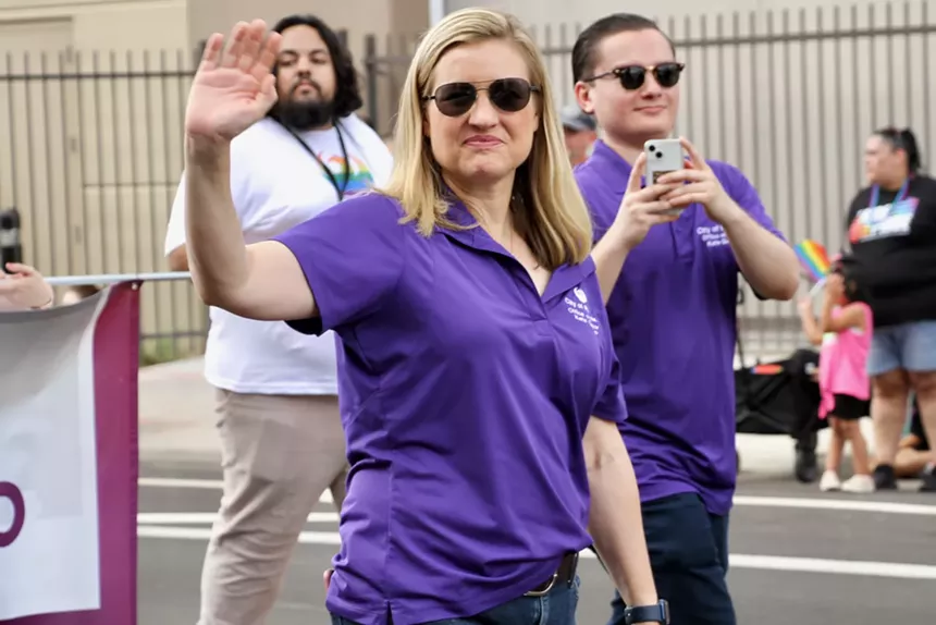 kate gallego waves in a purple polo shirt