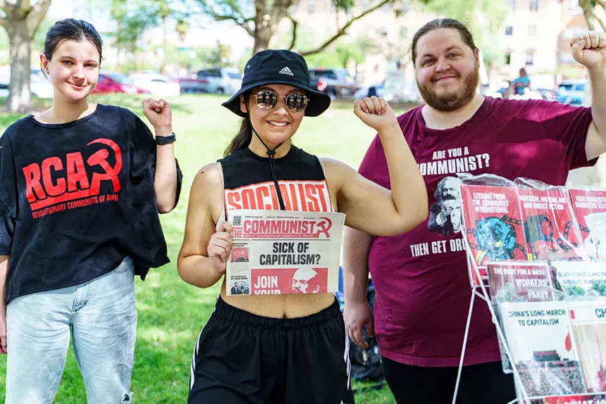 protesters hold up pro-communist and pro-socialist signs