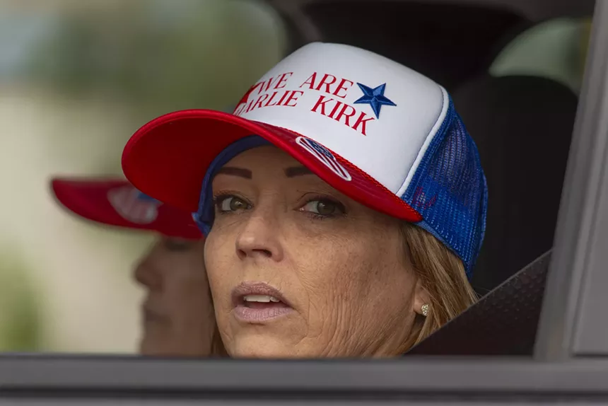 a woman in a car in a "we are charlie kirk" hat