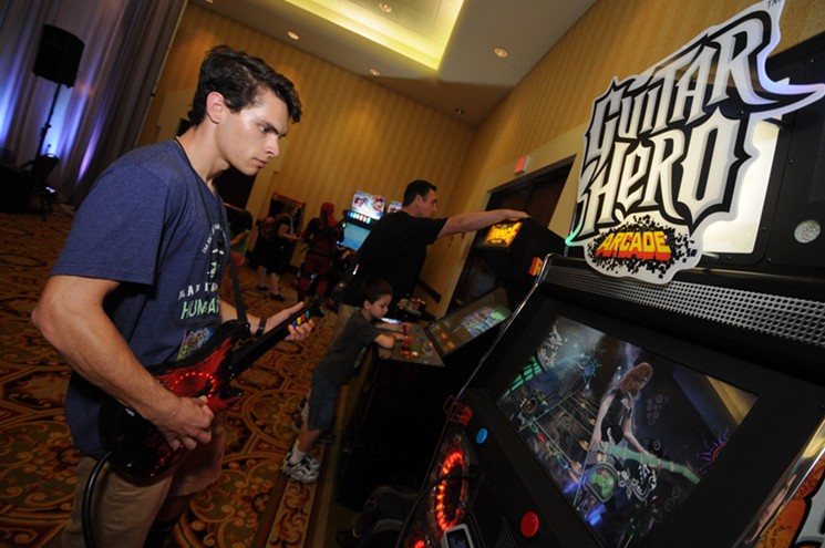 A Game On Expo attendee jams out on the Guitar Hero arcade edition at last year's event. - BENJAMIN LEATHERMAN