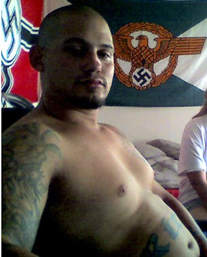 A younger pic of Ricci, as he lounges in a room decked out with Nazi battle flags. - MARICOPA COUNTY SUPERIOR COURT