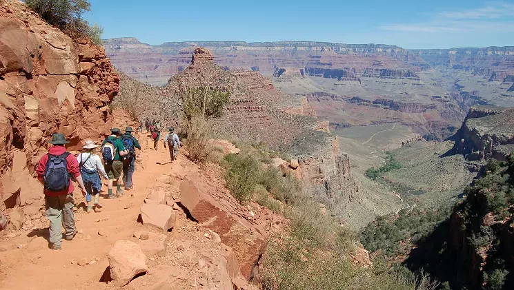 Grand Canyon's Bright Angel Trail leads to the Colorado River, but there's no need to trek its 10 miles to get to the bottom. At the edge of the valley in this photo, you can see the lush trees of Indian Garden. To its front left is a trail that crosses the middle of a mesa called Tonto Platform. Hike to the end of this trail to see the Colorado River and avoid a much longer hike to the bottom. - NPS PHOTO BY MICHAEL QUINN/FLICKR CREATIVE COMMONS