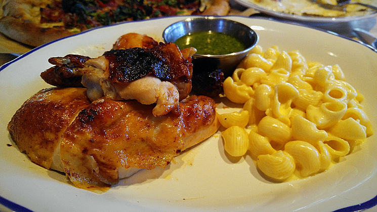 The half-chicken rotisserie option with a side of macaroni and cheese and the jalapeño pesto sauce. - PATRICIA ESCARCEGA