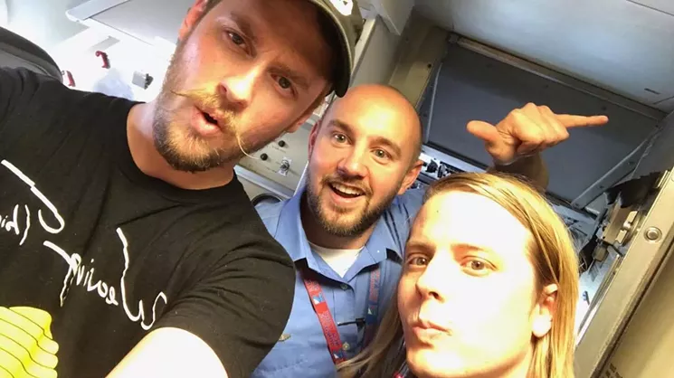 Sundressed's Forrest Waldorf and Trevor Hedges take a selfie with flight attendant Oliver Smith after their in-flight performance. - TREVOR HEDGES