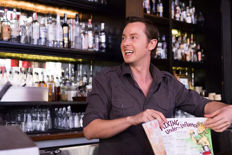 Bitter & Twisted proprietor Ross Simon shows off the bar 's latest menu, their most expensive to create thus far. - SHELBY MOORE