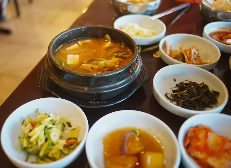 A pot of piping hot doenjang jjigae surrounded by various banchan at Hodori in Mesa. - MEAGAN MASTRIANI