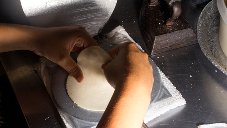 Chef Nadia Holguin presses tortillas, which she'll cook up briefly on the stovetop. - SHELBY MOORE