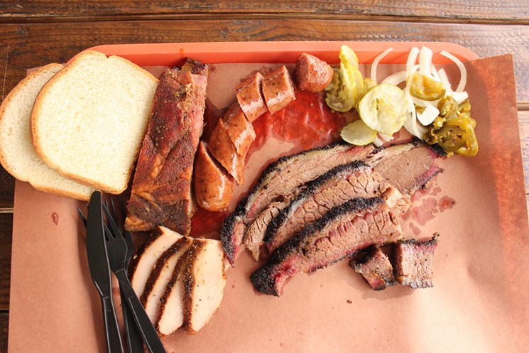 A Little Miss BBQ platter of brisket (fatty, lean, and burnt ends), turkey, ribs, and a sausage link, plus garnish and white bread. - CHRIS MALLOY