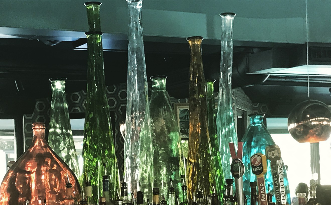Clear and colorful bottles accessorize the middle of the bar which leads to the fun and festive atmosphere during happy hour.