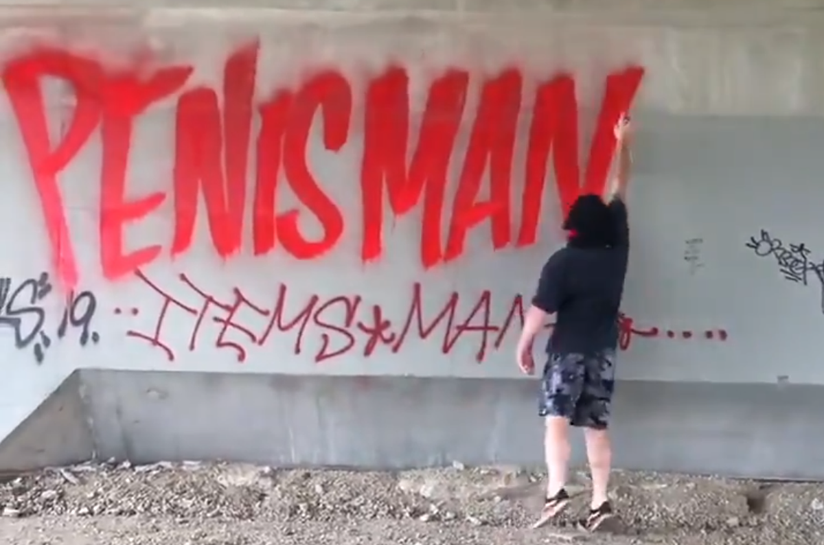 In this screenshot of a Twitter video posted by @Lushsux on February 11, a man spray paints "Penis Man" on a wall. It's unclear when or where the video was taken.