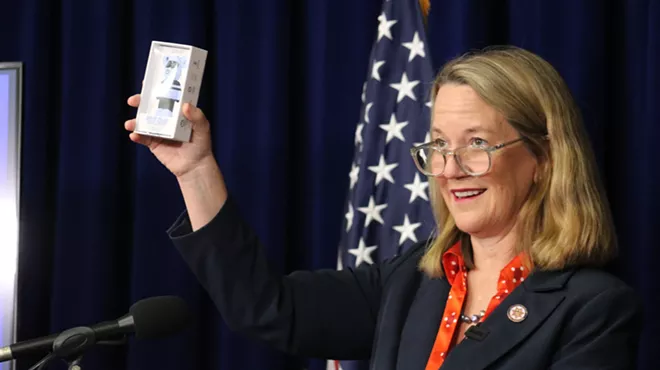 kris mayes holds up a vape cartridge at a press conference