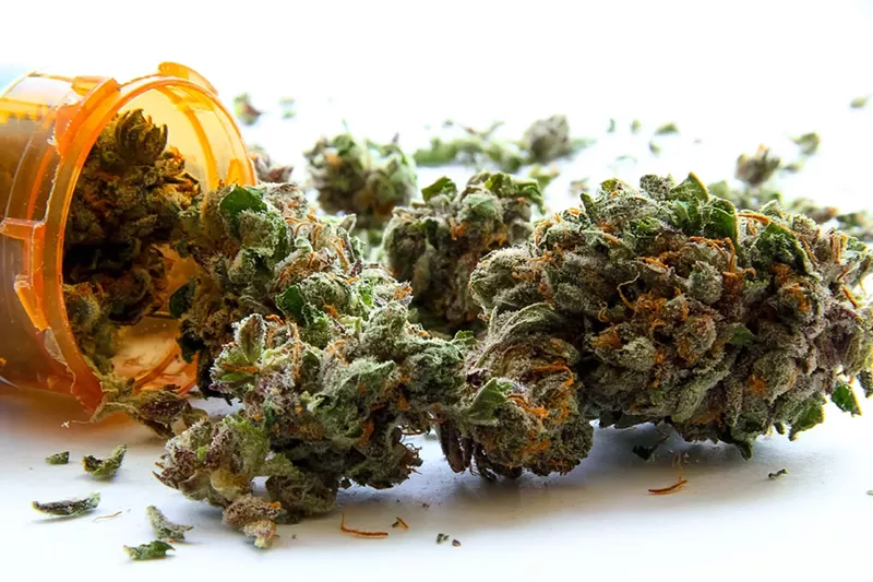 Image: marijuana coming out of a prescription bottle.