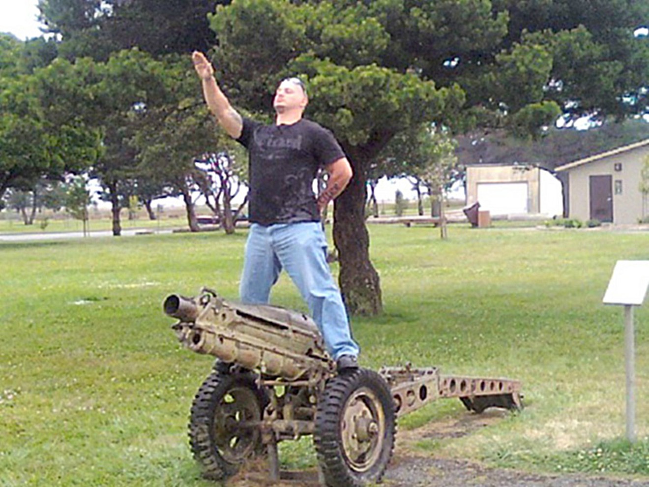 Accused murderer and neo-Nazi Travis Ricci, sieg heiling atop a howitzer.