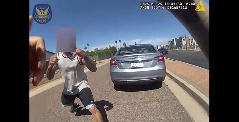 Image: body-camera footage showing a man with a sleeveless shirt and tattoos down his arms squaring up to fight