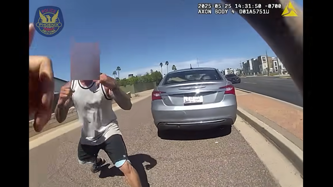 body-camera footage showing a man with a sleeveless shirt and tattoos down his arms squaring up to fight