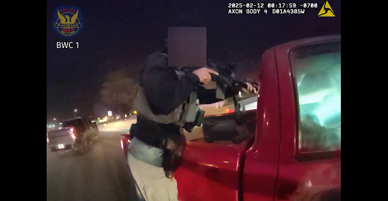 Image: body-cam footage shoting a police officer pointing a rifle through the back window of a pickup truck