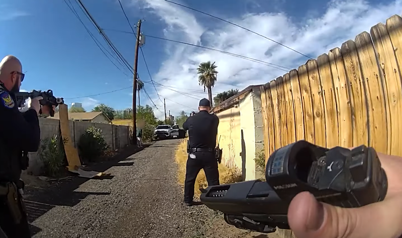 Image: body cam footage of police officers pointing their guns at someone