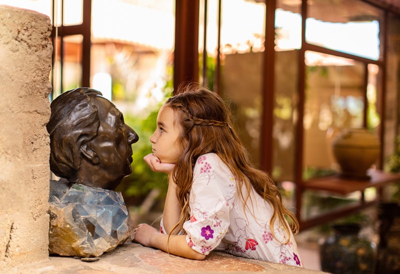 A student checks out a bust of famed architect Frank Lloyd Wright.