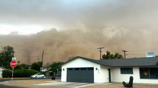 a haboob billows behind a white house