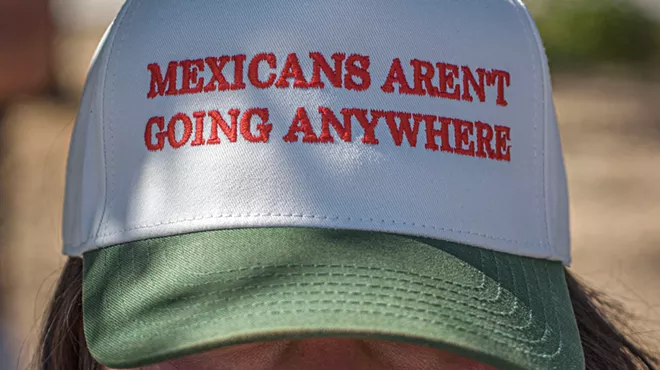 A woman wearing a hat that reads Mexicans Aren't Going Anywhere
