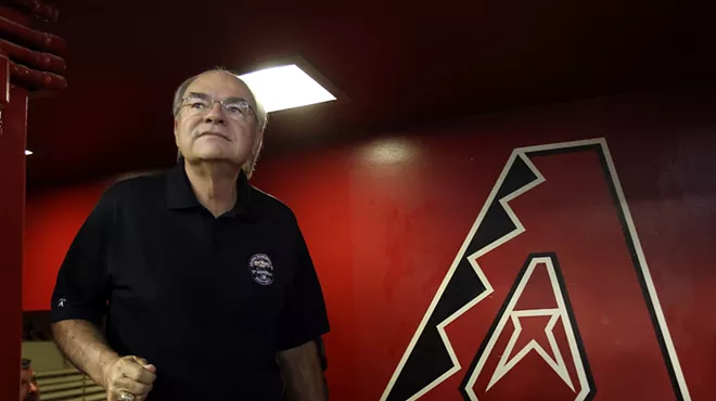 Arizona Diamondbacks owner Ken Kendrick, standing in front of a large Diamondbacks "A" logo.