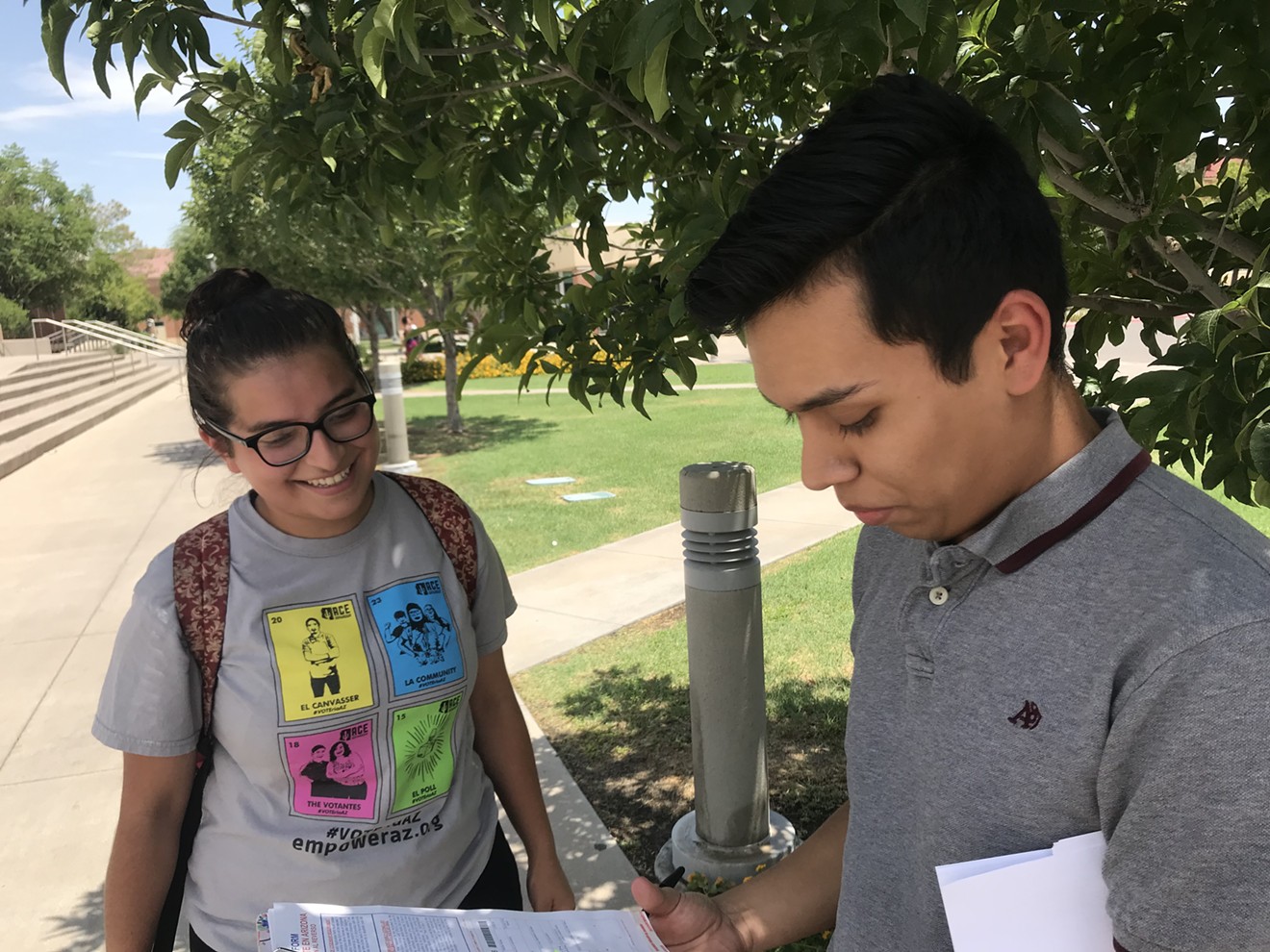 Aryhannah Meza, 18, helps Jovany James Hernandez register to vote outside Phoenix College.