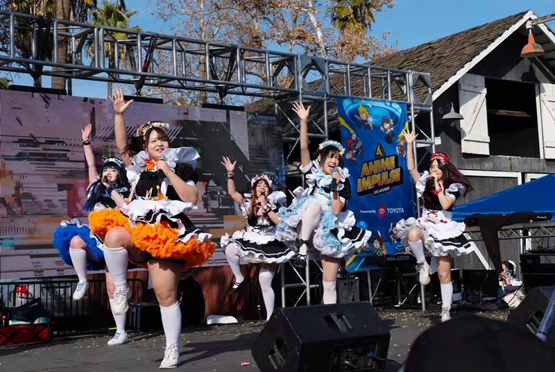 Image: Costumed anime performers onstage at a convention.